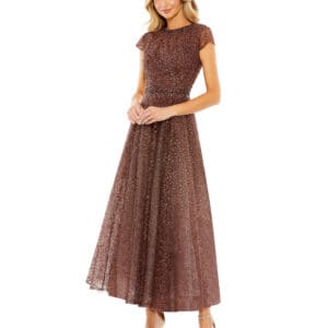 A woman in a Brown Embellished Cap Sleeve A-Line Dress stands with relaxed arms. The dress features short cap sleeves and a long, flowing skirt. She complements the outfit with open-toed heels.