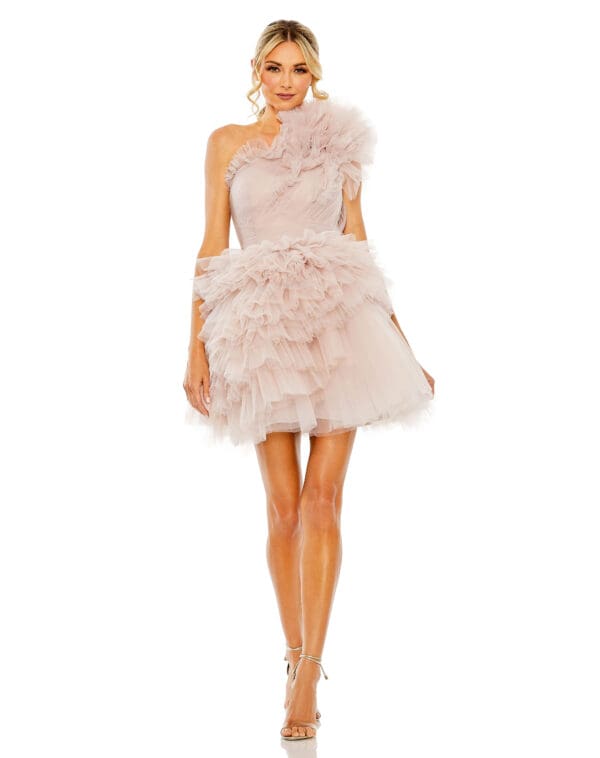 A woman in a Tulle Ruffle One Shoulder Mini Dress and strappy heels stands against a white background.