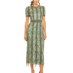 A woman in a green dress standing on the side of a road.