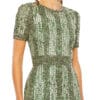 A woman wearing a High Neck Short Sleeve Crystal Fringe Column Dress in green.