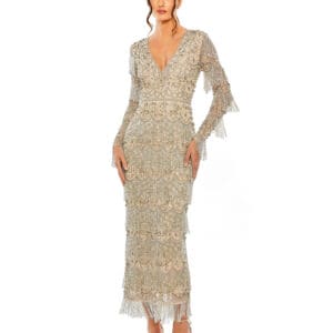 A woman stands in front of a plain white background wearing the V Neck Beaded Fringe Embellished Dress, a long ornate silver outfit featuring fringe and beaded details.