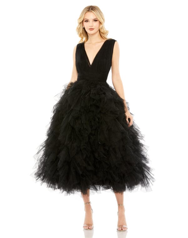 A woman stands in heels against a white background wearing a black Ruffled Cap Sleeve V-Neck A Line Tulle Dress.