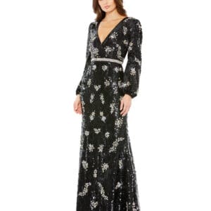 A person is wearing an Embellished Wrap Over Bishop Sleeve Gown, featuring a black floor-length design with sparkling floral patterns, standing against a plain white background.